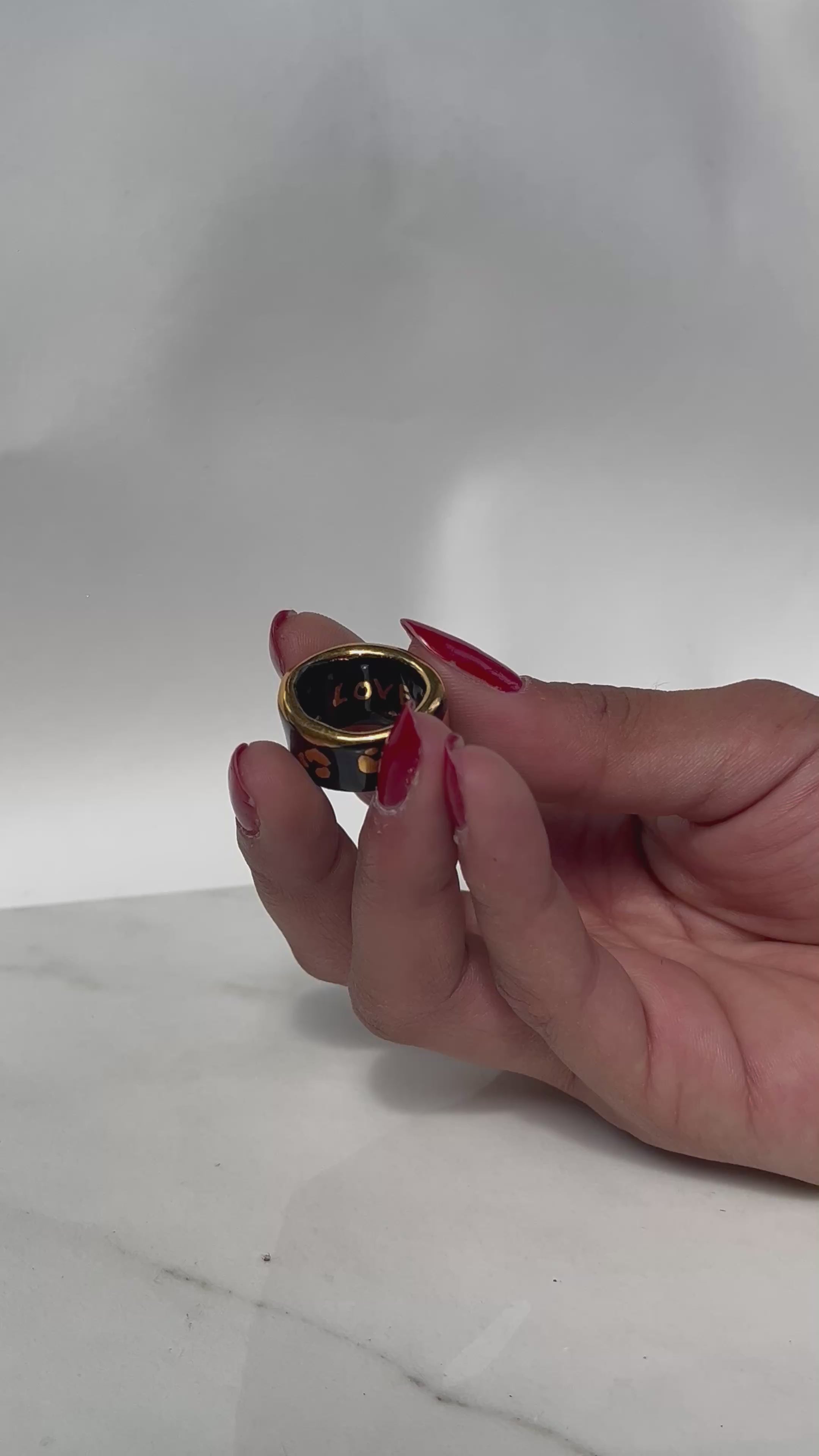 Une bague en porcelaine noir émaillée en taille 49, à motif léopards avec des tâches d'or liquide