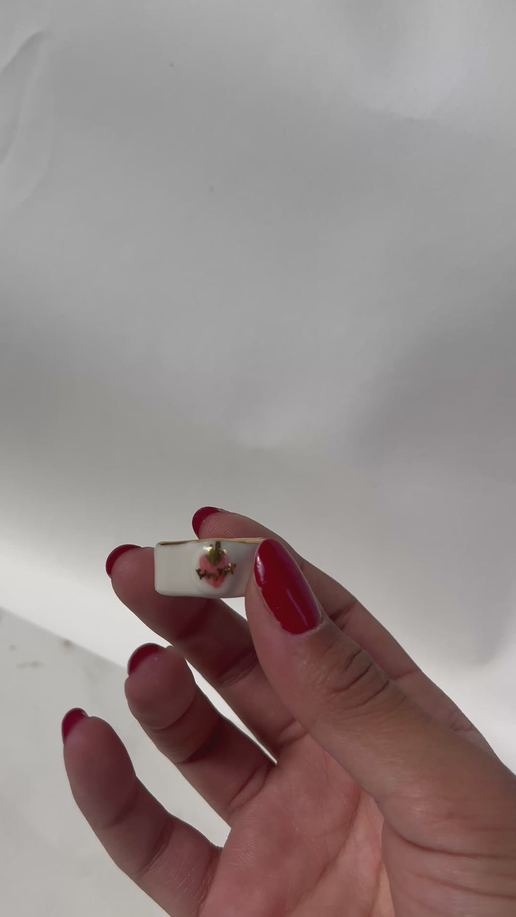 Bague asymétrique en porcelaine blanche émaillée en taille 52FR avec un motif coeur ex-voto peint à la main avec des détails en noirs et à l'or liquide. Fait à la main à Lyon