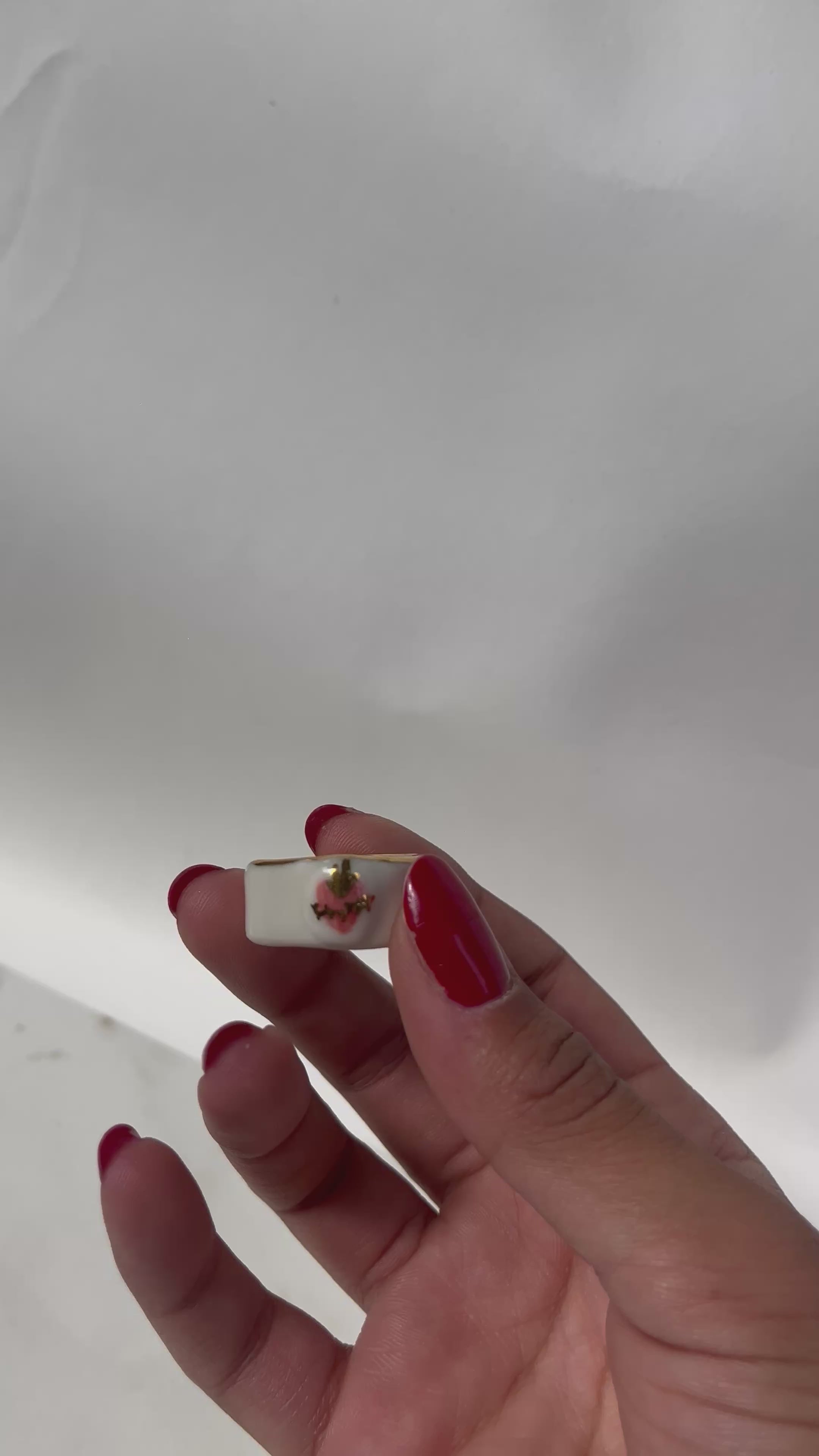 Bague asymétrique en porcelaine blanche émaillée en taille 52FR avec un motif coeur ex-voto peint à la main avec des détails en noirs et à l'or liquide. Fait à la main à Lyon